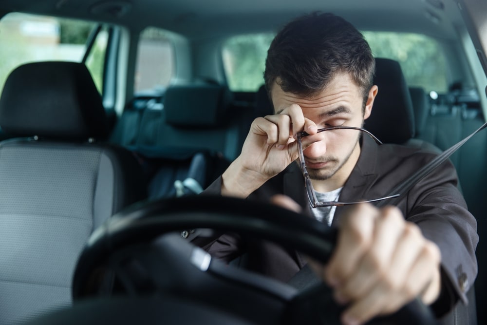 exhausted man driving a car